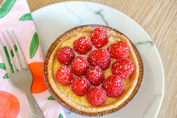 delicious dessert pie topped with fresh raspberries. sweet treat food on a plate. Pastry tart with custard and fruit