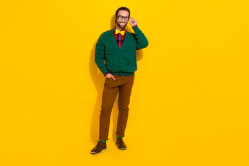 Full size portrait of satisfied glad person hand touch glasses toothy smile isolated on yellow color background