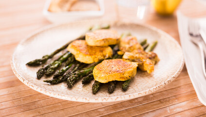 cooked dish. Chicken nuggets with green asparagus on plate