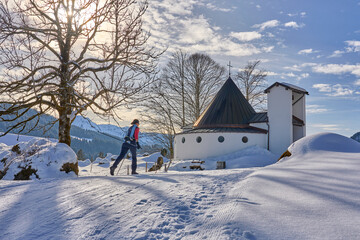 beautiful active senior woman cross-country skiing in fresh fallen powder snow in the Allgau alps...