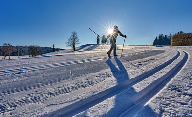 nice, active woman cross country skiing in the Bregenz Forest Mountains near Sulzberg, Vorarlberg,...