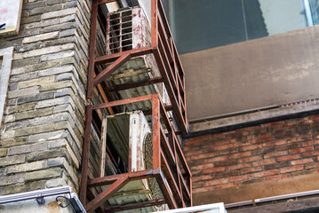 Close-up of an air conditioner outdoor unit installed outside an old residential building