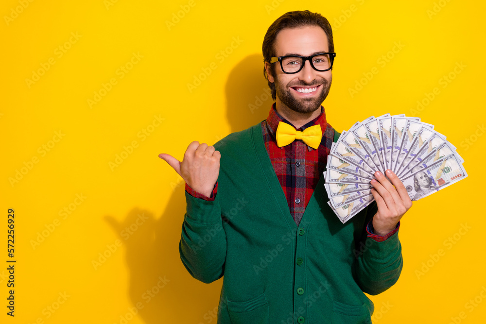 Wall mural Photo of positive cheerful smile guy brunet hair stylish outfit direct finger empty space new lottery win money isolated on yellow color background