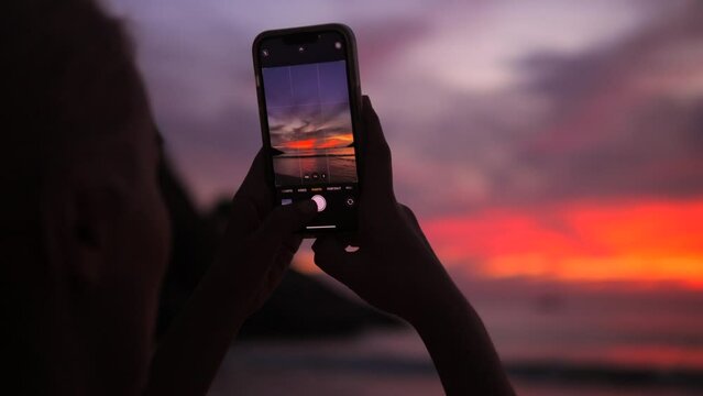 Young Traveler Woman Taking Amazing Sunset Photos on Tropical Island Using Mobile Phone, High Quality 4K Slowmotion Travel Concept Footage, Thailand.