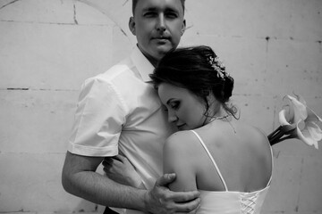 A couple in love,  The bride and groom are dressed in a wedding suit and dress, hugging, kissing ech other and posing together