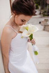 Beautiful bride in a graceful wedding dress, makeup and professional hairstyle posing outdoor