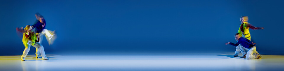 Music in moves. Young expressive contemp dance dancers dancing in neon light. Concept of dance, youth, hobby, dynamics, movement, action, ad. Banner with copy space