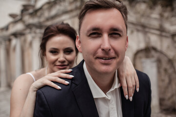 A couple in love,  The bride and groom are dressed in a wedding suit and dress, hugging, kissing ech other and posing together