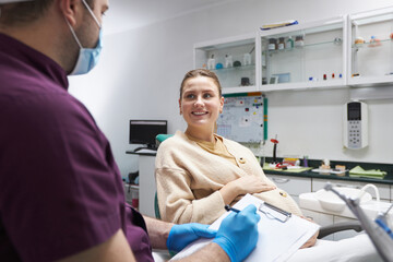 Young pregnant woman with a beautiful smile listens to the dentist in dental clinic