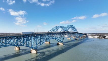 Beautiful South Grand Island Bridge crossing Niagara River with cars and trucks driving under blue sky and clouds 
