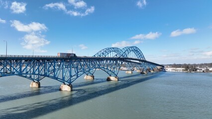 Fototapeta na wymiar Beautiful South Grand Island Bridge crossing Niagara River with cars and trucks driving under blue sky and clouds 