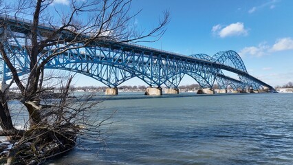 Beautiful South Grand Island Bridge crossing Niagara River with cars and trucks driving under blue sky and clouds 