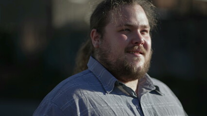 Close up face of a young overweight happy caucasian male walks forward with joyful expression