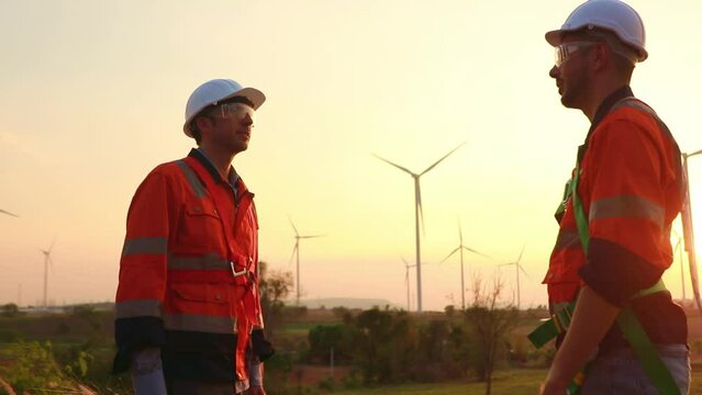Team of male technicians work before the sun sets, looks at the clock, finishes, shakes hands, congratulates and disperses to go home.