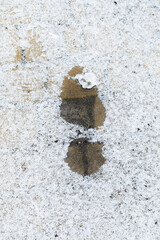 Blurred image of a footprint on a snowy pavement.
