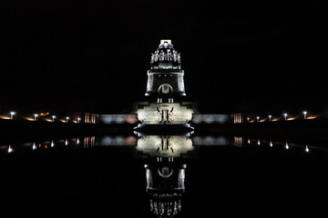 Night shot of the Monument to the Battle of the Nations in Leipzig, reflection on the water,...