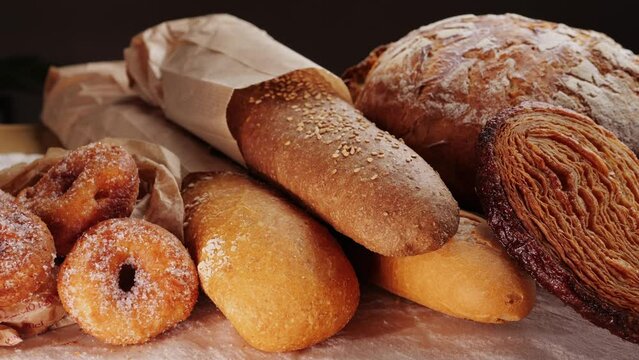 Bread displayed by the baker, assortment of Spanish baguette and traditional bakery shop desserts. Close up of European bread supermarket.