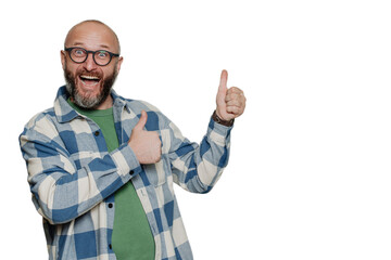 Excited mid adult Caucasian bald beardy man in spectacles, plaid shirt screams with wide opened mouth and eyes gestures thumb up  points at empty space over transparent background. Mockup, sale.