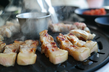 Close-up of pork being cooked on an iron plate