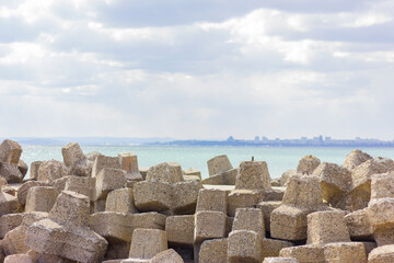 pile of large stones on a pier near a sea beach.