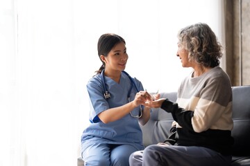 Healthcare worker or nurse caregiver giving pills, showing a prescription drug to senior woman. Elderly healthcare concept