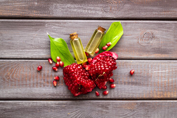 Pomegranate fruit and leaves and bottle of pomegranate seed oil
