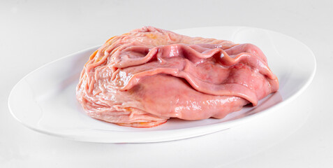Fresh pork offal on a white plate on a white background
