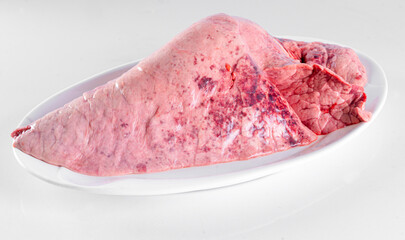 Fresh pork offal on a white plate on a white background