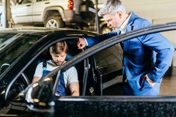 Obraz na płótnie Canvas Demanding dissatisfied customer in car service. An unpleasant conversation with a car service worker.