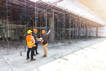 Concept of construction. Engineer, architect and designer working together at the construction site, Foreman or engineer checking the accuracy of the construction work by using blueprints..