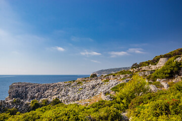 Fototapeta na wymiar Gagliano del Capo. The beautiful panorama on the blue sea, from the rocky cliff of Salento. The nature trail that leads from the Ciolo bridge to the spectacular Cipolliane caves. Sunny day in summer.