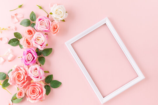 Happy Women's Day decoration concept made from rose flower place around frame picture on pastel background.