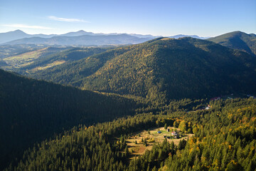 Aerial view of hillside with dark spruce forest trees at fall bright day. Beautiful scenery of wild mountain woodland