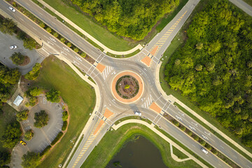 Aerial view of road roundabout intersection with moving cars traffic. Rural circular transportation...