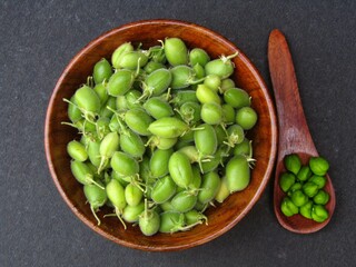 Green Chickpeas in a wooden bowl on black background top view 