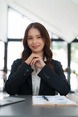 Beautiful asian business woman working on a laptop at office. Financial analysis and tax concept.