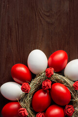 deep red Easter eggs in nest top view background, selective focus image. Happy Easter card