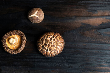 Dry Shiitake mushroom on dark wood table.