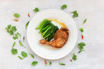 Healthy food chicken braised has kale garlic chili sauce in plate on white wood table.