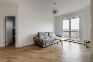 Living room with a gray sofa and a round coffee table and a huge window
