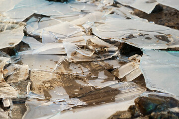 Primo piano di una lastra di ghiaccio crepata in giardino, natura in inverno
