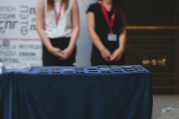 Process of checking in on a conference congress forum event, registration desk table, visitors and attendees receiving a name badge and entrance wristband bracelet and register electronic ticket