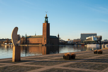 Stockholm City Hall (Stockholms stadshus) on sunny evening with Solbåten (The sun boat) by...