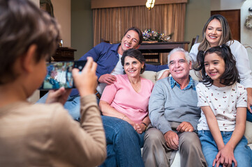 The grandson takes a portrait photo of his family with a smartphone.