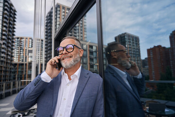 Attractive man with beard in casual clothes talking on phone