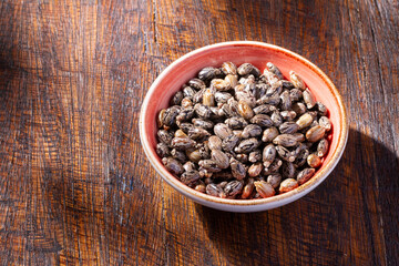 Castor grains and oil on the table, close-up image