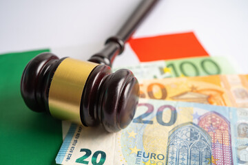 Gavel for judge lawyer and US dollar banknotes on Italy flag, finance concept.