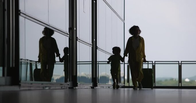 A mother and son go to a hotel after their flight is cancelled. A woman with child, frustrated by the delay in their flight, go to a hotel provided by company. Flight delayed, waiting for next flight