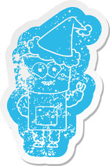 happy cartoon distressed sticker of a robot waving hello wearing santa hat