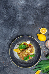 fish fillet breaded in nuts with pepper sauce and vegetables, vertical image. top view. place for text